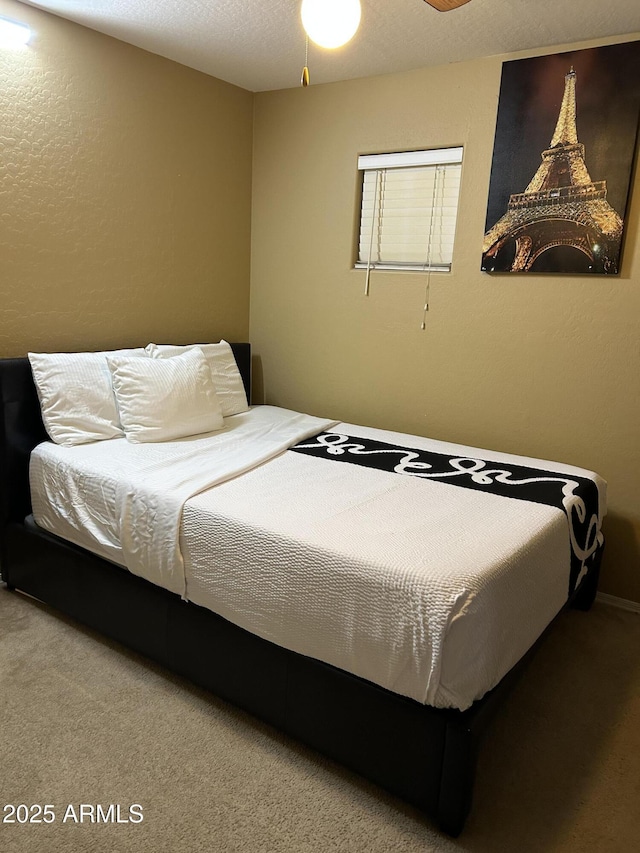 bedroom featuring a textured ceiling and carpet flooring