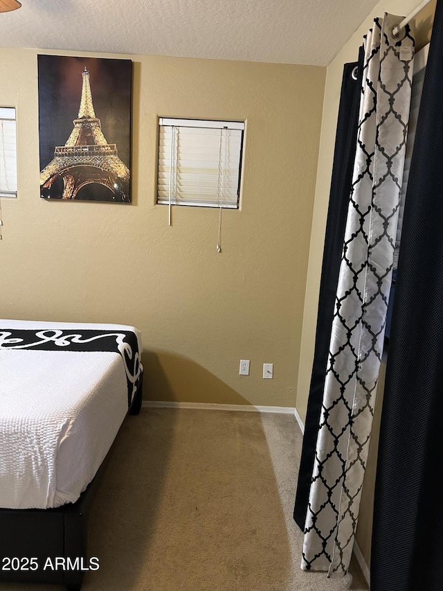 bedroom featuring a textured ceiling and carpet flooring