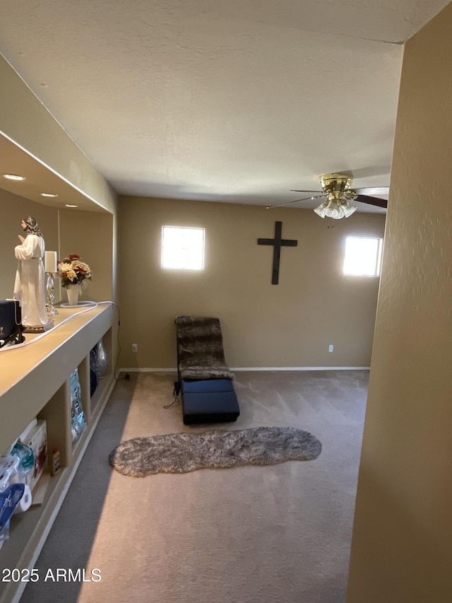 living area featuring ceiling fan and carpet flooring