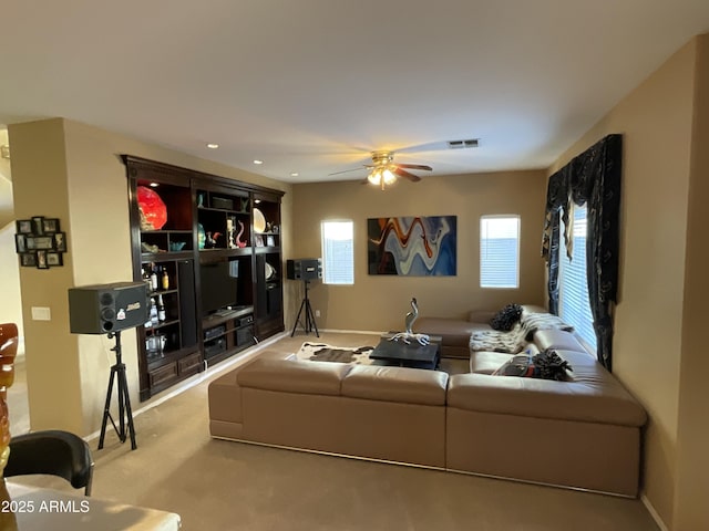 carpeted living room with a healthy amount of sunlight and ceiling fan