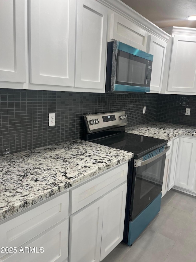 kitchen with white cabinets, tasteful backsplash, electric range, and light stone counters