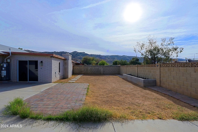 view of yard with a mountain view, a patio area, and gas water heater