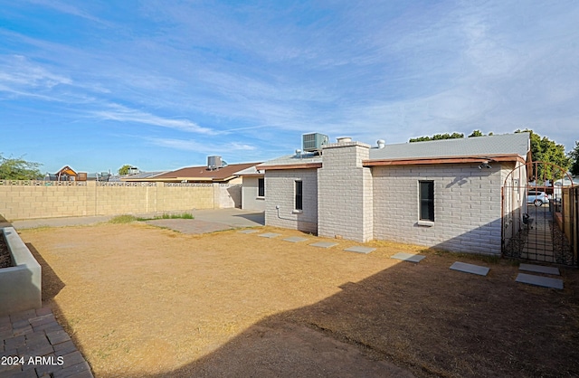 rear view of property featuring central AC unit and a patio area