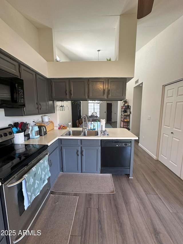 1718 S Longmore St Unit 53, Mesa, AZ 85202 - kitchen with black appliances, dark wood finished floors, light countertops, a high ceiling, and a peninsula