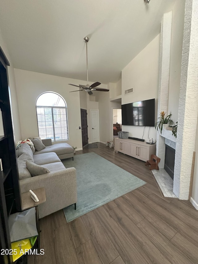 1718 S Longmore St Unit 53, Mesa, AZ 85202 - living room with a ceiling fan, dark wood-style flooring, high vaulted ceiling, and a brick fireplace