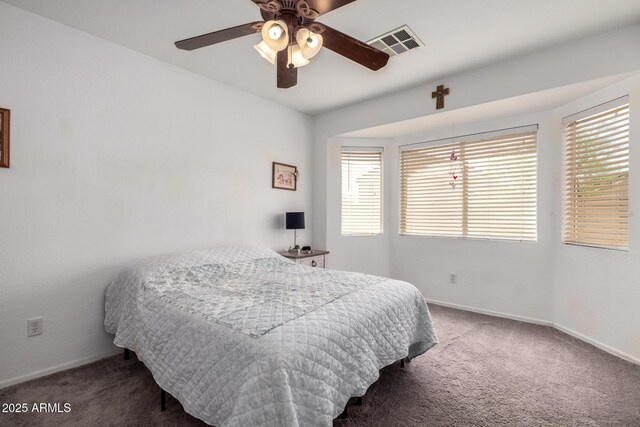 carpeted bedroom with a ceiling fan, baseboards, and visible vents