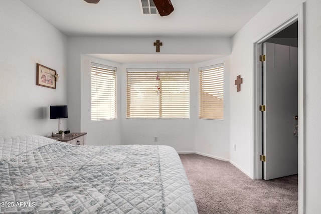 carpeted bedroom featuring ceiling fan, visible vents, and baseboards
