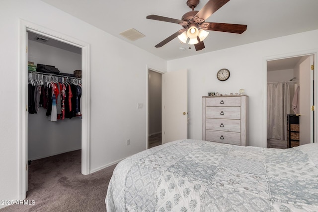 bedroom with visible vents, carpet floors, a closet, a walk in closet, and a ceiling fan