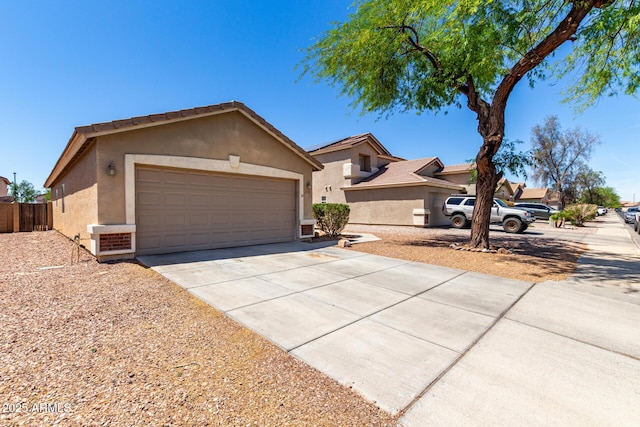 single story home with fence, stucco siding, an attached garage, and driveway