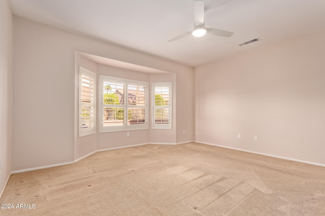 unfurnished room with ceiling fan and light carpet