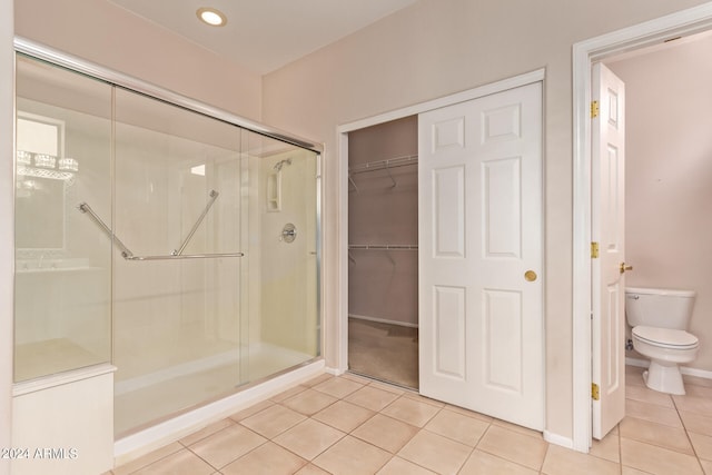 bathroom with tile patterned floors, toilet, and walk in shower