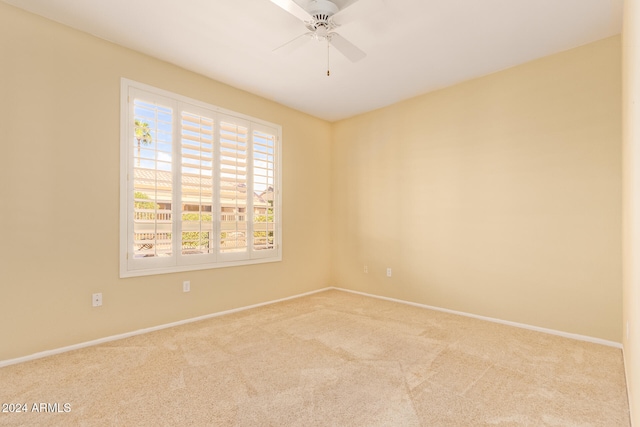 carpeted spare room featuring ceiling fan