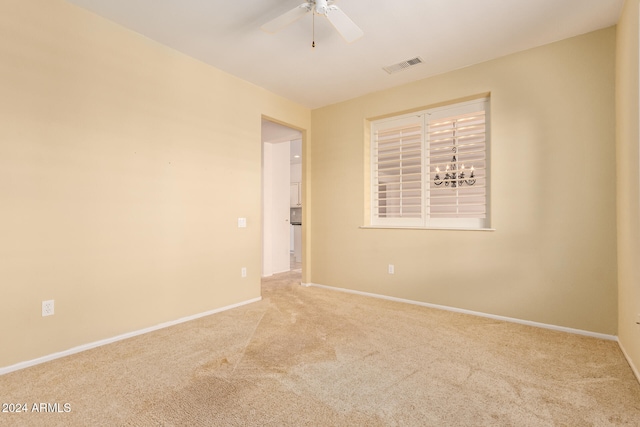 spare room featuring light colored carpet and ceiling fan