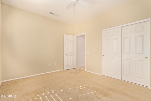 unfurnished bedroom with light carpet, a closet, and ceiling fan