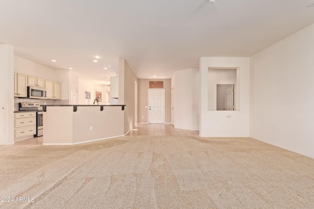 unfurnished living room featuring light colored carpet