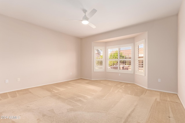 unfurnished room with ceiling fan and light colored carpet