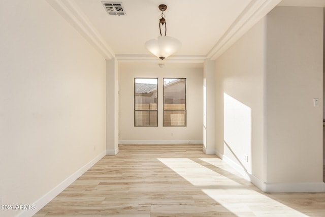 empty room with light hardwood / wood-style floors and ornamental molding