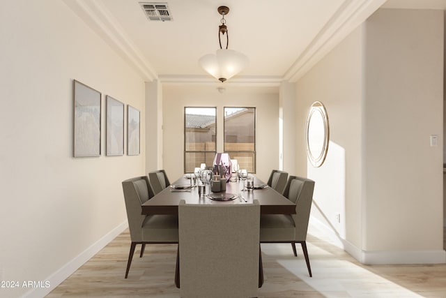 dining room with light hardwood / wood-style flooring and ornamental molding