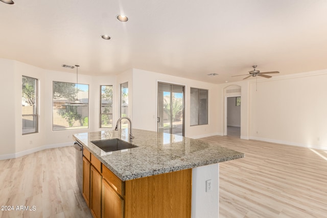 kitchen featuring light hardwood / wood-style floors, ceiling fan, sink, light stone counters, and hanging light fixtures