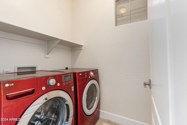 washroom featuring washing machine and dryer and light hardwood / wood-style flooring