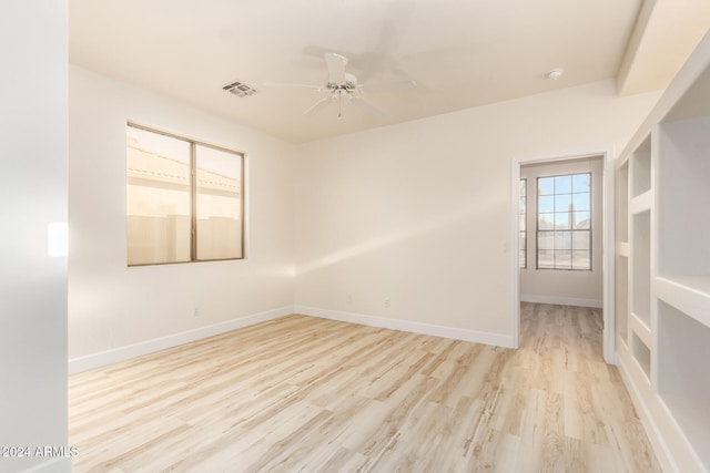 unfurnished room with light wood-type flooring and ceiling fan