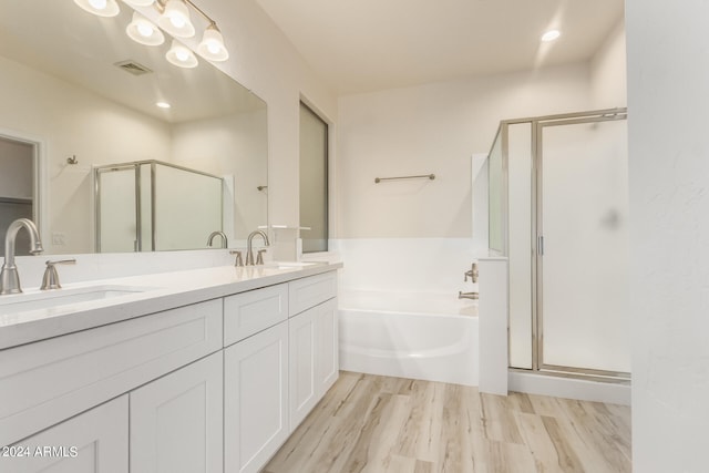 bathroom featuring wood-type flooring, separate shower and tub, and vanity