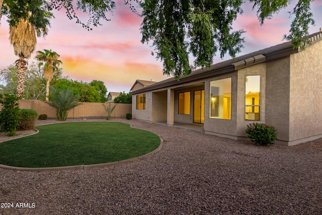 back house at dusk with a yard