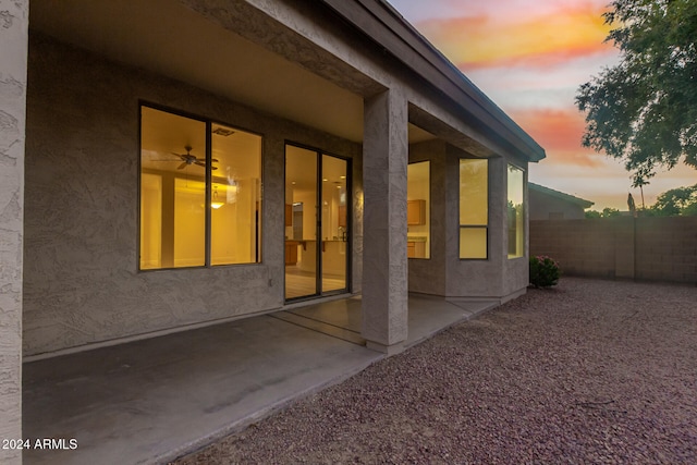 property exterior at dusk featuring a patio