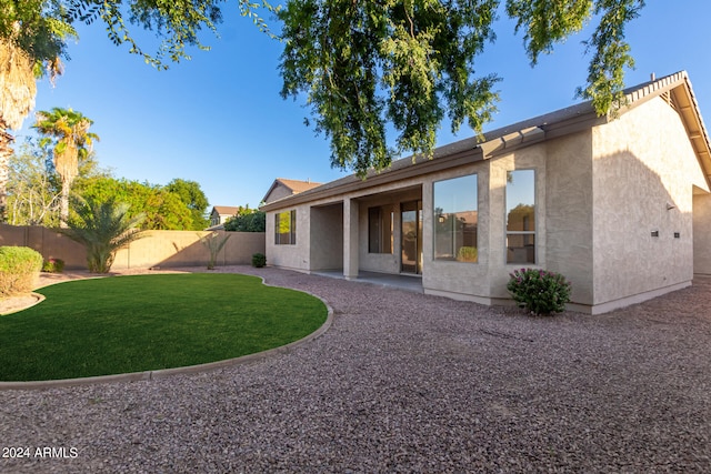 back of property with a yard and a patio area