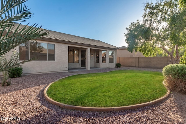 rear view of house with a lawn and a patio area