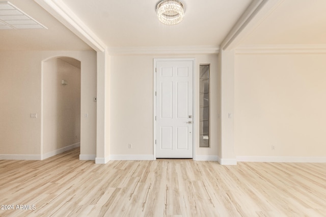 entryway featuring crown molding, a chandelier, and light hardwood / wood-style floors