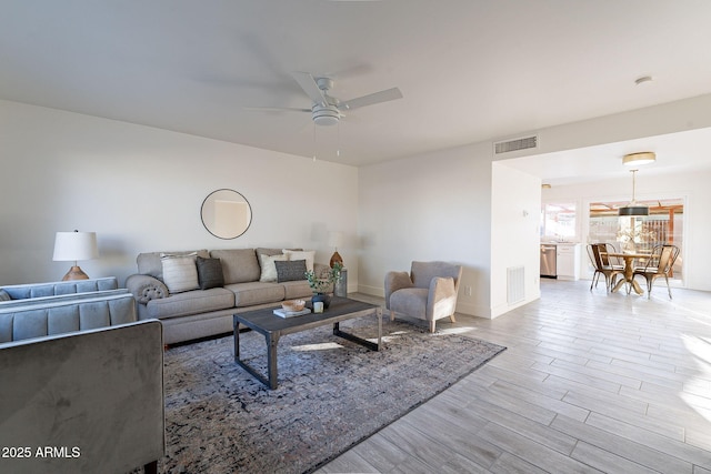 living room with ceiling fan and light wood-type flooring