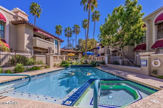 view of swimming pool featuring a hot tub