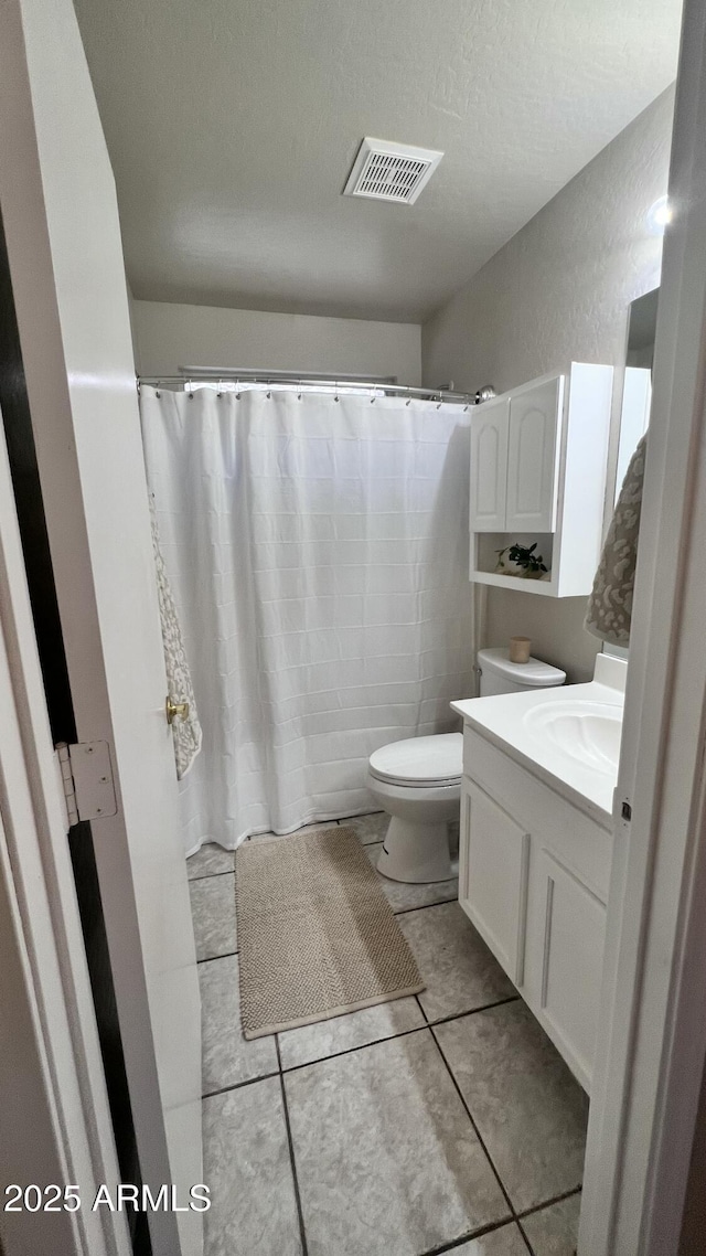 bathroom with tile patterned floors, toilet, visible vents, a shower with shower curtain, and vanity