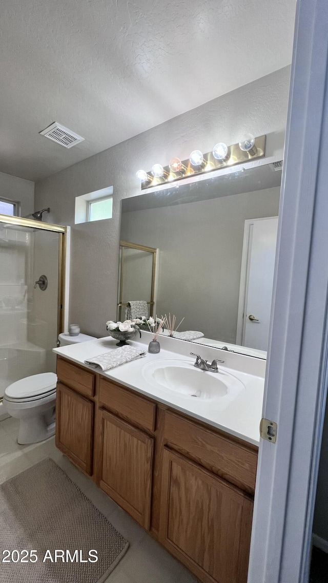 full bath with visible vents, toilet, vanity, a textured ceiling, and a stall shower
