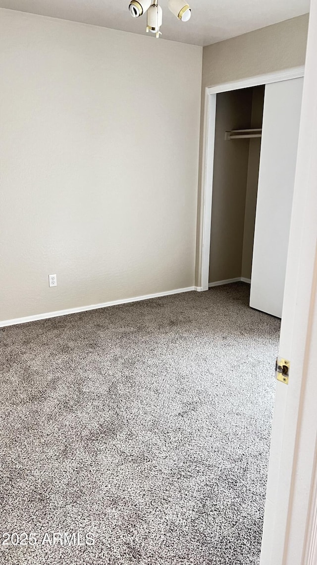 unfurnished bedroom with a closet and baseboards