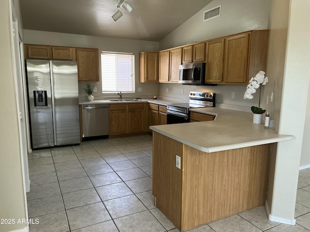 kitchen featuring a sink, light tile patterned floors, stainless steel appliances, light countertops, and lofted ceiling