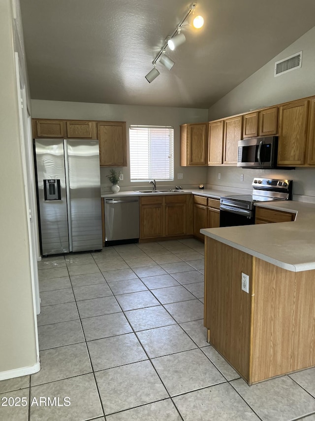 kitchen with light tile patterned floors, stainless steel appliances, light countertops, rail lighting, and visible vents
