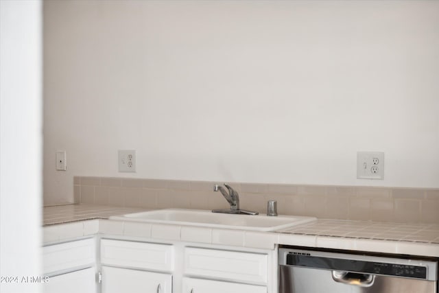 kitchen with tile countertops, white cabinetry, dishwasher, and sink