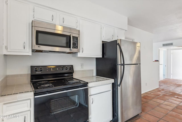 kitchen featuring white cabinetry, tile counters, and stainless steel appliances