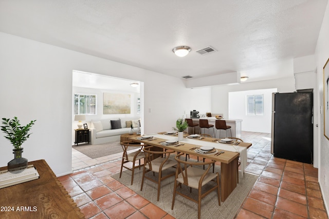 dining area with light tile patterned floors and a textured ceiling