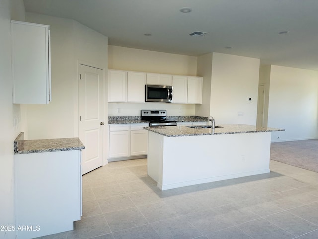 5701 E Iris Dr, Florence, AZ 85132 - kitchen with stainless steel appliances, a sink, light stone counters, and white cabinetry