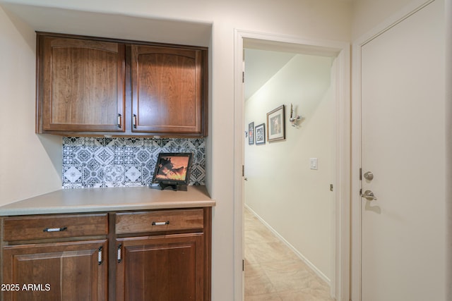 kitchen featuring backsplash, light countertops, and baseboards