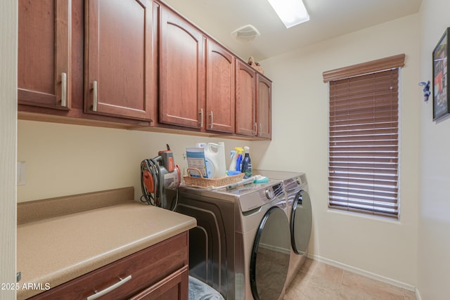 laundry area with light tile patterned floors, cabinet space, baseboards, and washer and clothes dryer
