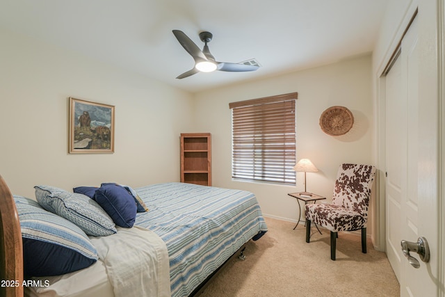 bedroom featuring a closet, baseboards, light carpet, and a ceiling fan