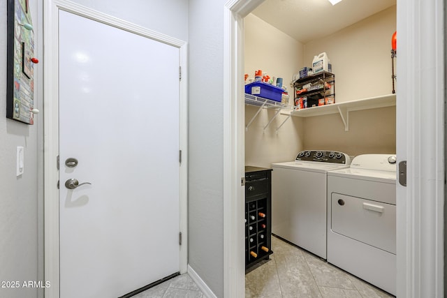 laundry area featuring washer and clothes dryer and light tile patterned floors