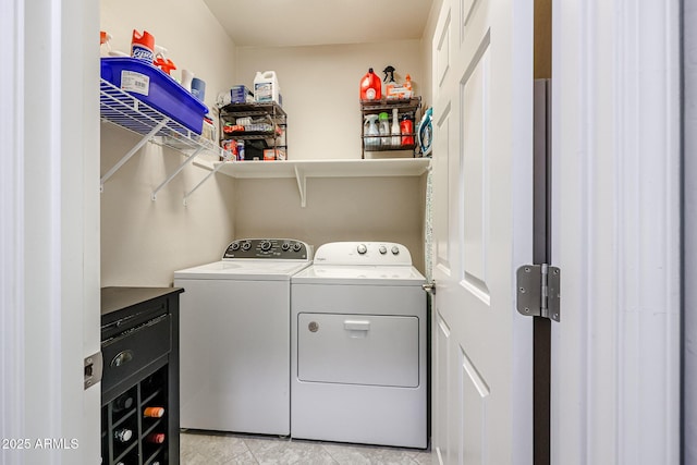 clothes washing area with light tile patterned flooring and washer and clothes dryer