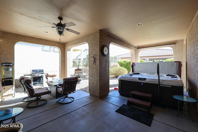 view of patio / terrace with ceiling fan, a grill, and a hot tub