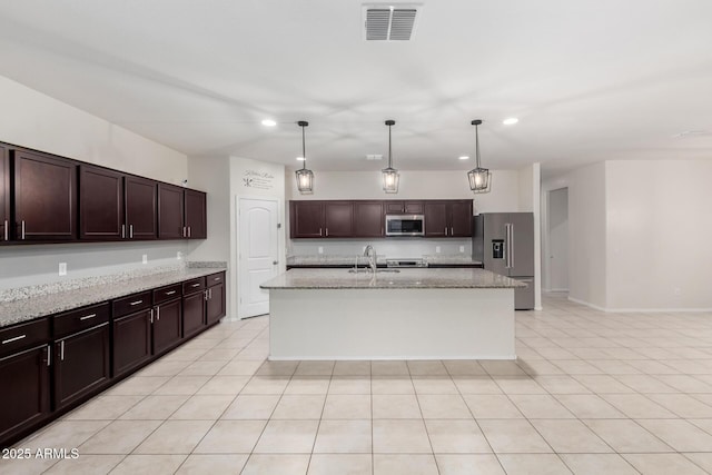 kitchen featuring dark brown cabinetry, visible vents, stainless steel appliances, and a sink