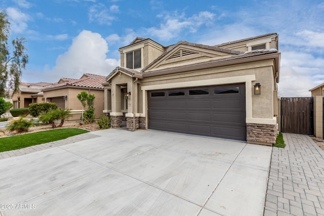 view of front of house with stone siding, stucco siding, an attached garage, and concrete driveway